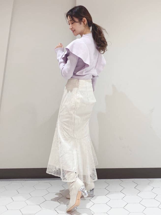 ホワイト系のスカート、パープル系のニット/セーターを着用したレディースの冬コーディネートの2枚目の写真