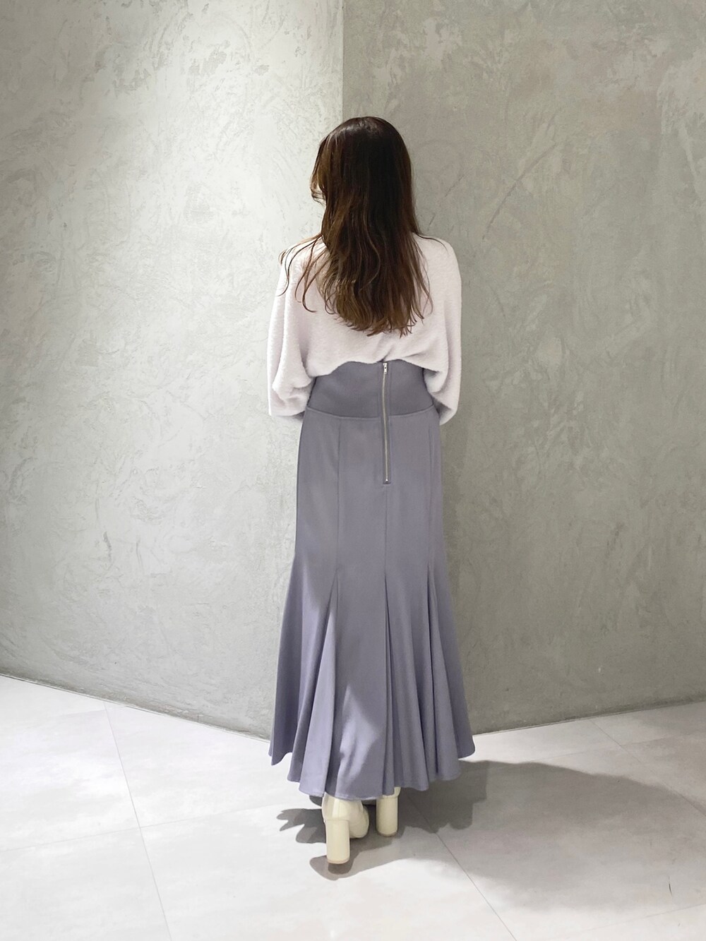 ホワイト系のブーツ、ブルー系のスカート、パープル系のニット/セーターを着用したレディースの秋コーディネートの7枚目の写真