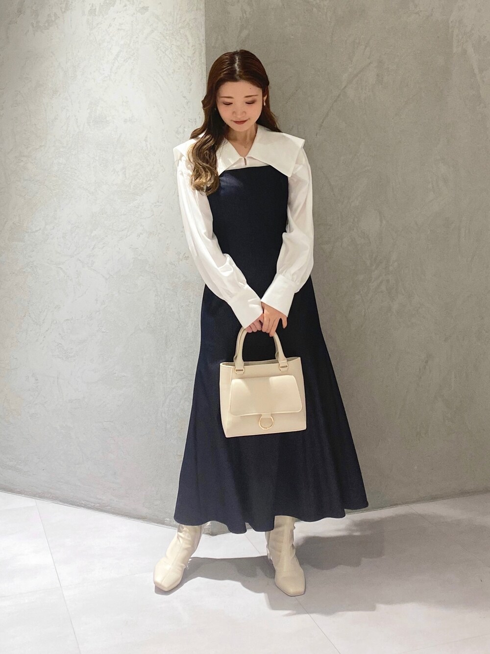 ホワイト系のブーツ、ブルー系のワンピース、ホワイト系のハンドバッグを着用したレディースの冬コーディネートの3枚目の写真