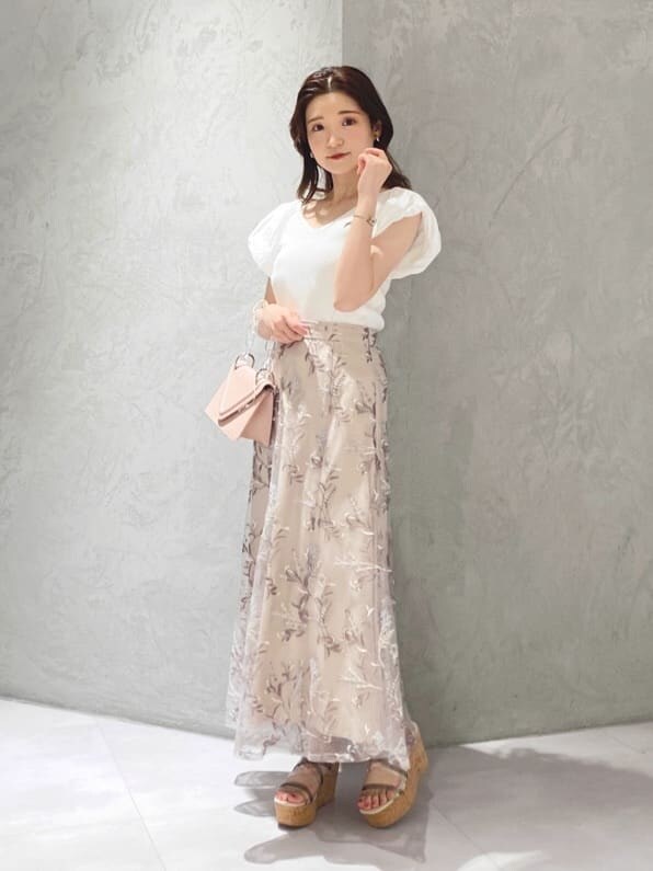 ピンク系のスカート、ホワイト系のニット/セーターを着用したレディースの春コーディネートの3枚目の写真