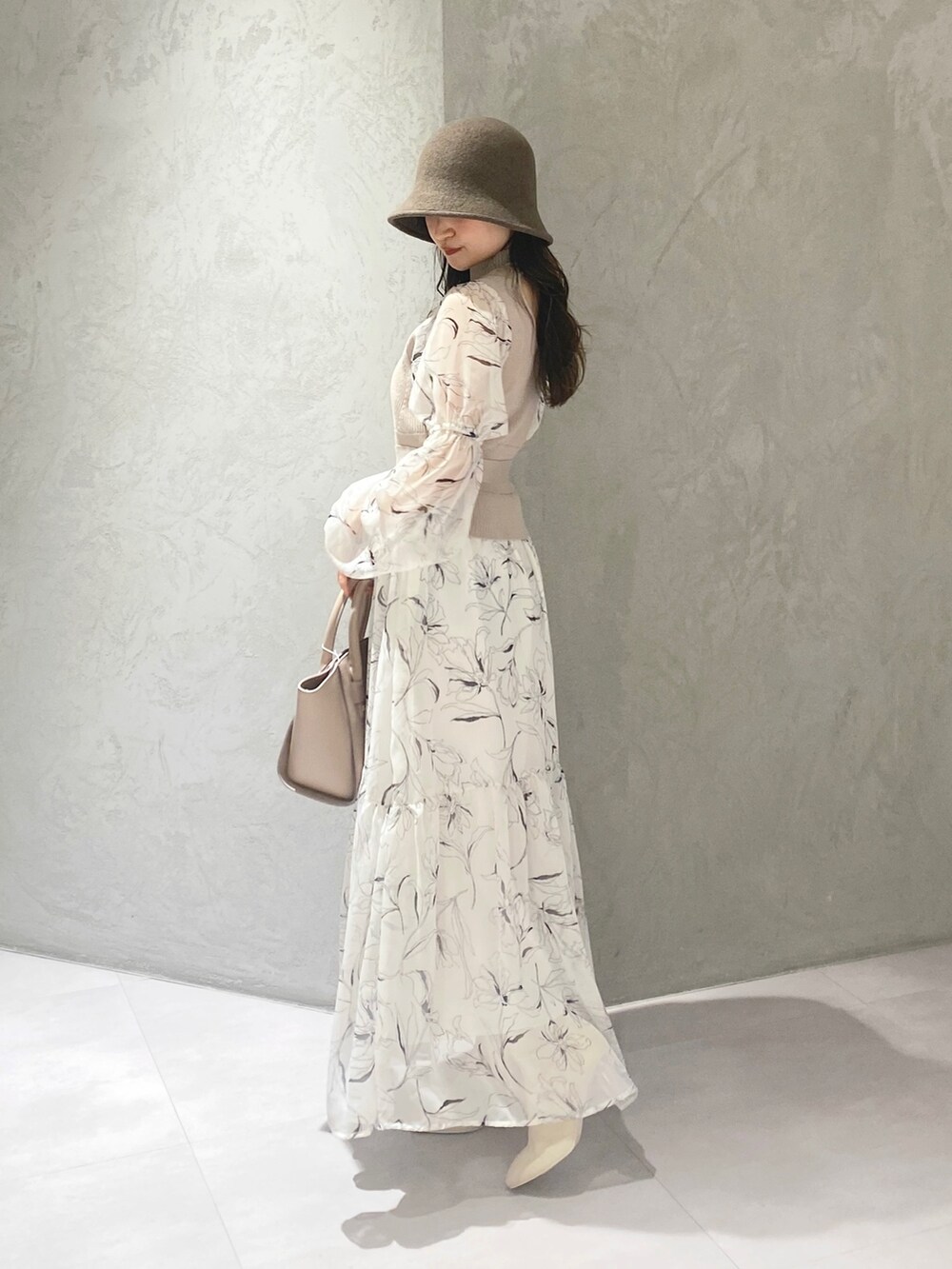 ホワイト系のムートンコート、ホワイト系のブーツ、ベージュ系のハンドバッグを着用したレディースの冬コーディネートの8枚目の写真