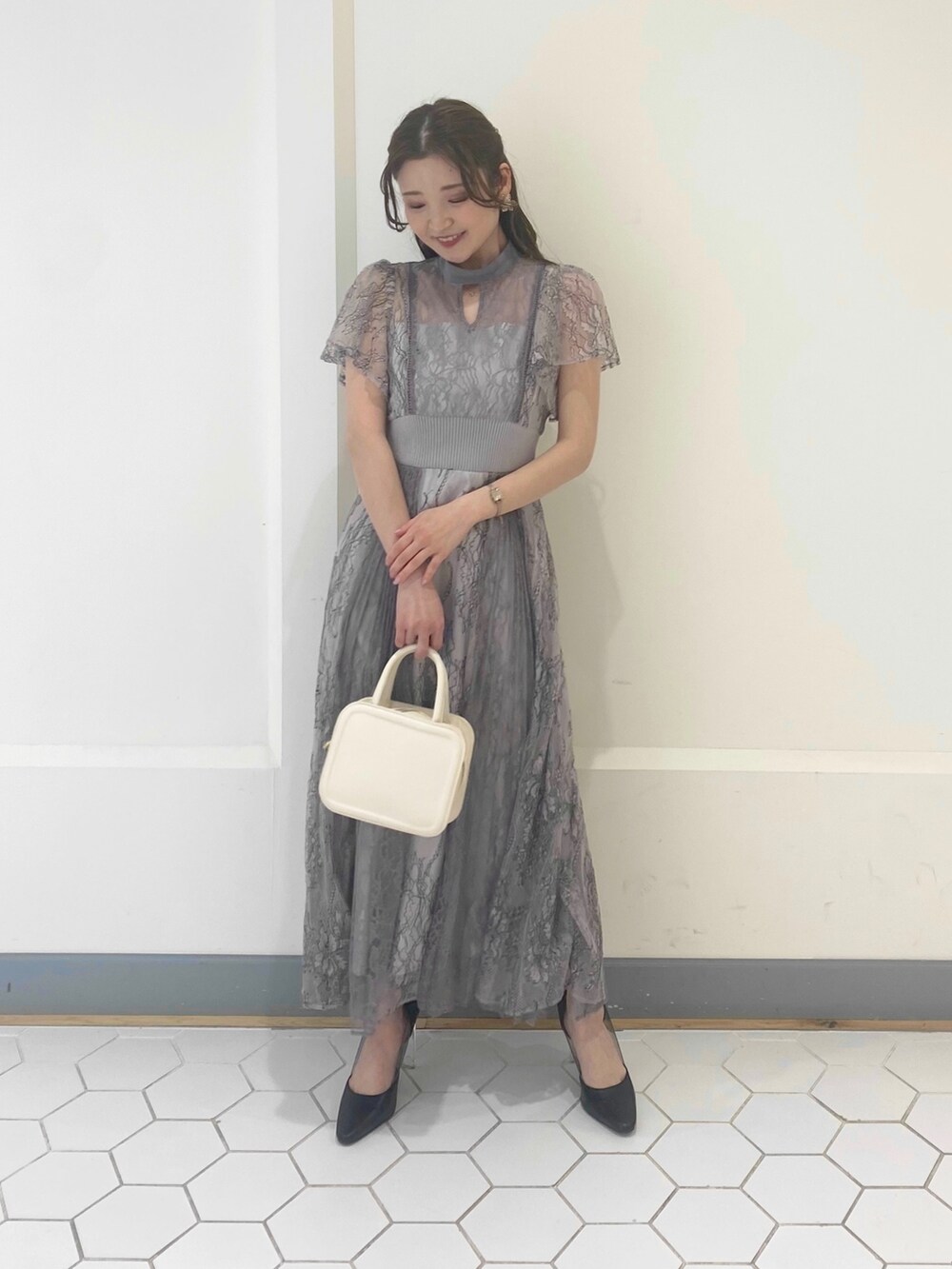 パープル系のドレス、ブラック系のパンプスを着用したレディースの冬コーディネートの3枚目の写真