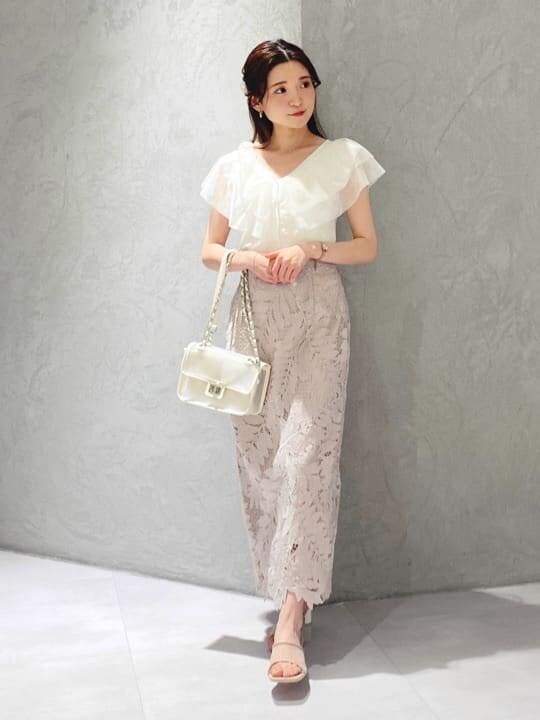 ピンク系のスカート、ベージュ系のサンダル、ホワイト系のカーディガン/ボレロを着用したレディースの夏コーディネートの3枚目の写真