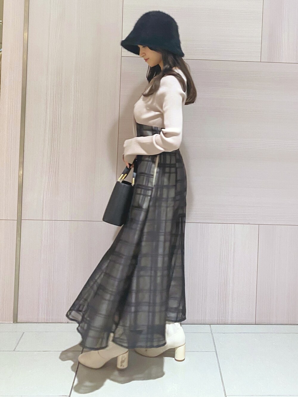 ピンク系のワンピース、ブラック系のハンドバッグ、ホワイト系のブーツを着用したレディースの秋コーディネートの5枚目の写真