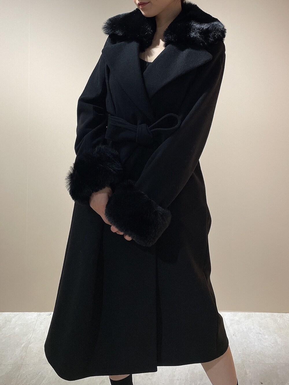 ブラック系のチェスターコート、ブラック系のブーツを着用したレディースの秋コーディネートの4枚目の写真