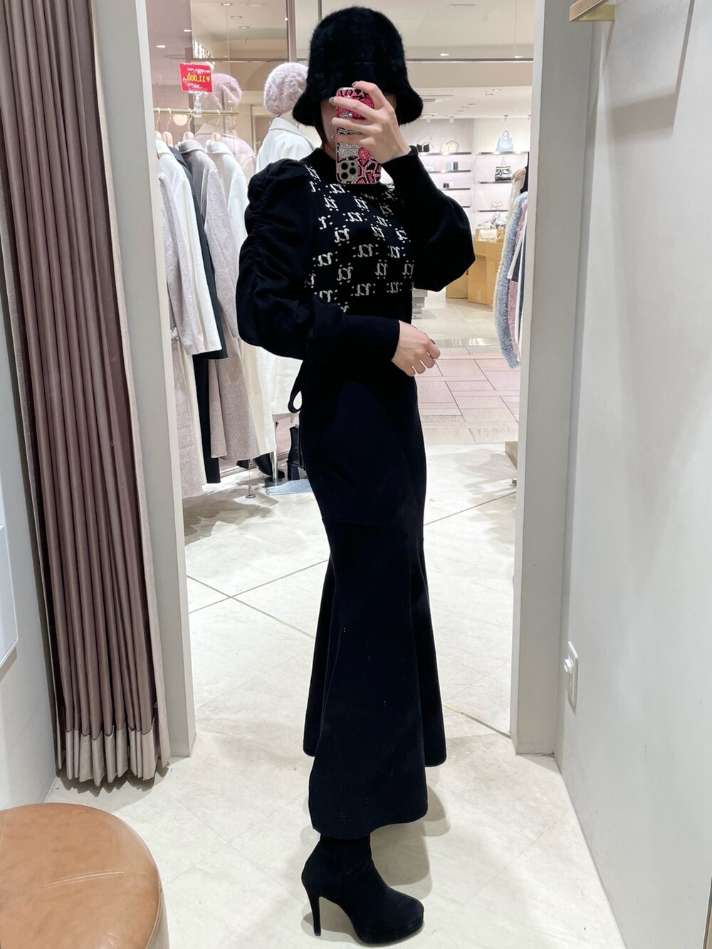 ブラック系のワンピース、ブラック系のブーツを着用したレディースの冬コーディネートの3枚目の写真