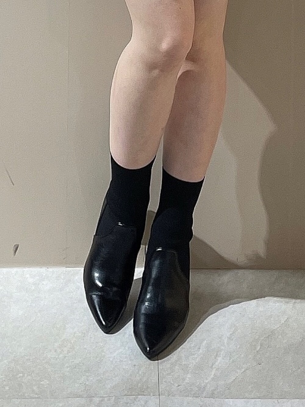 ブラック系のダウンジャケット/コート、ブラック系のワンピース、ブラック系のブーツを着用したレディースの秋コーディネートの9枚目の写真