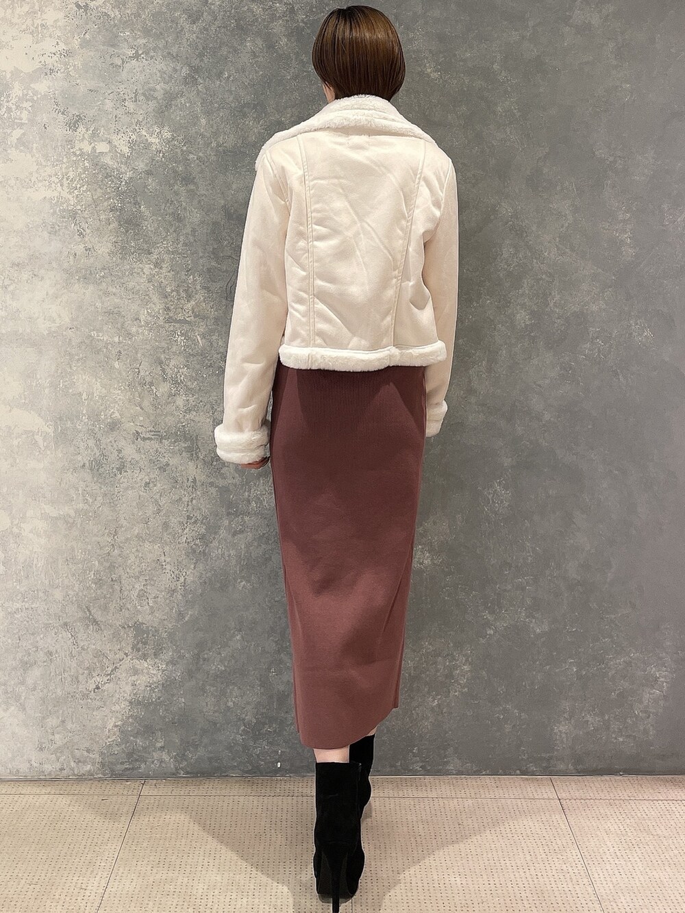 ブラック系のブーツ、ホワイト系のブルゾン、ブラウン系のワンピースを着用したレディースの秋コーディネートの3枚目の写真