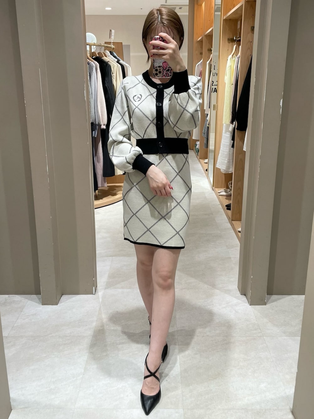 ホワイト系のカーディガン/ボレロ、ホワイト系のスカート、ブラック系のパンプスを着用したレディースの冬コーディネートの4枚目の写真