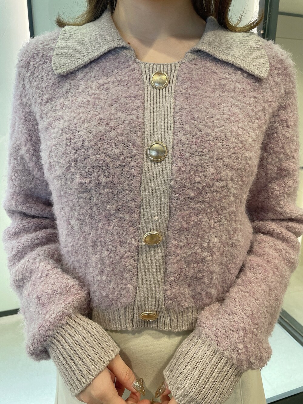 パープル系のニット/セーター、ホワイト系のスカート、ブラウン系のブーツを着用したレディースの冬コーディネートの5枚目の写真