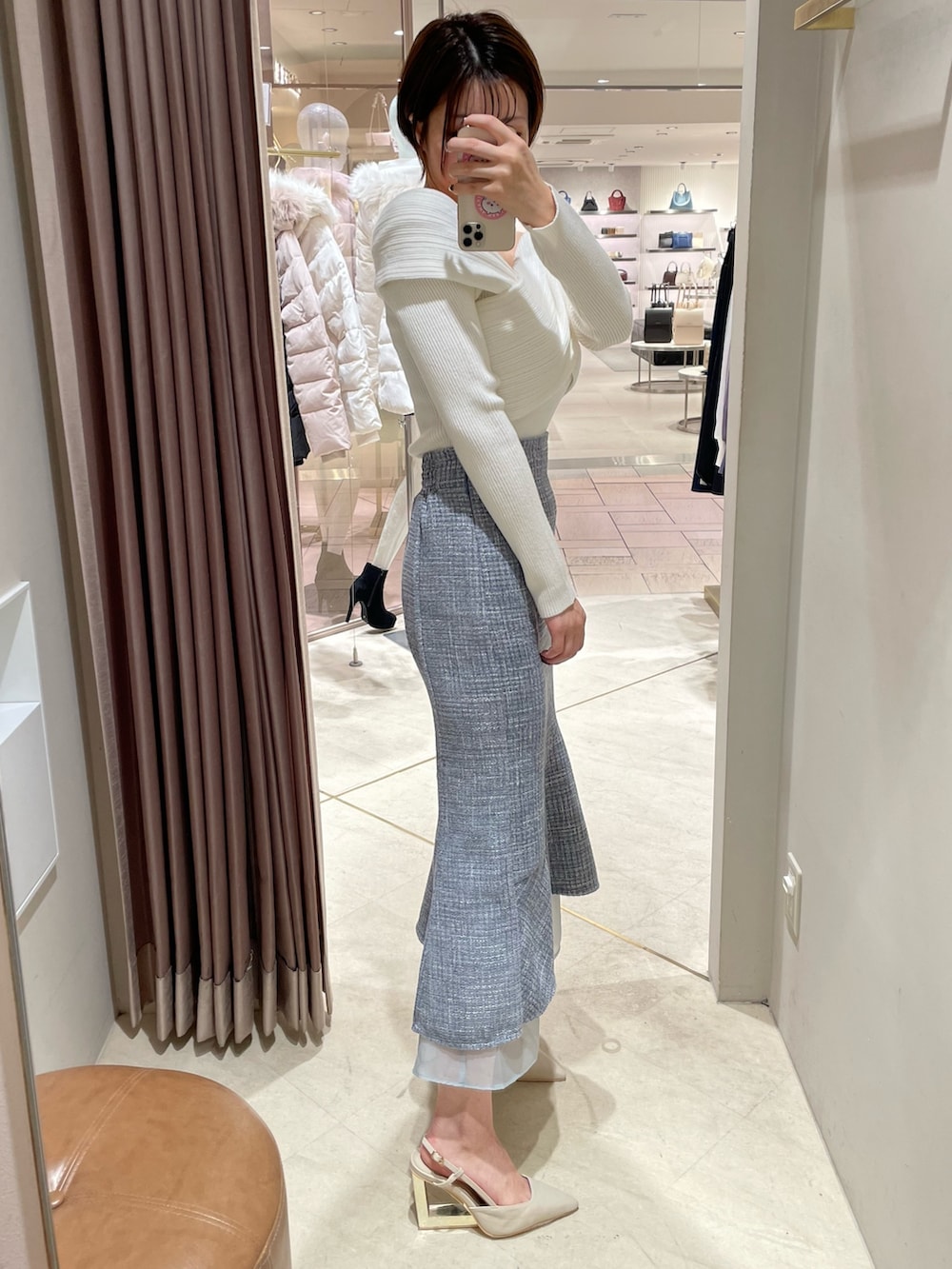 ホワイト系のニット/セーター、ブルー系のスカート、ベージュ系のサンダルを着用したレディースの秋コーディネートの2枚目の写真