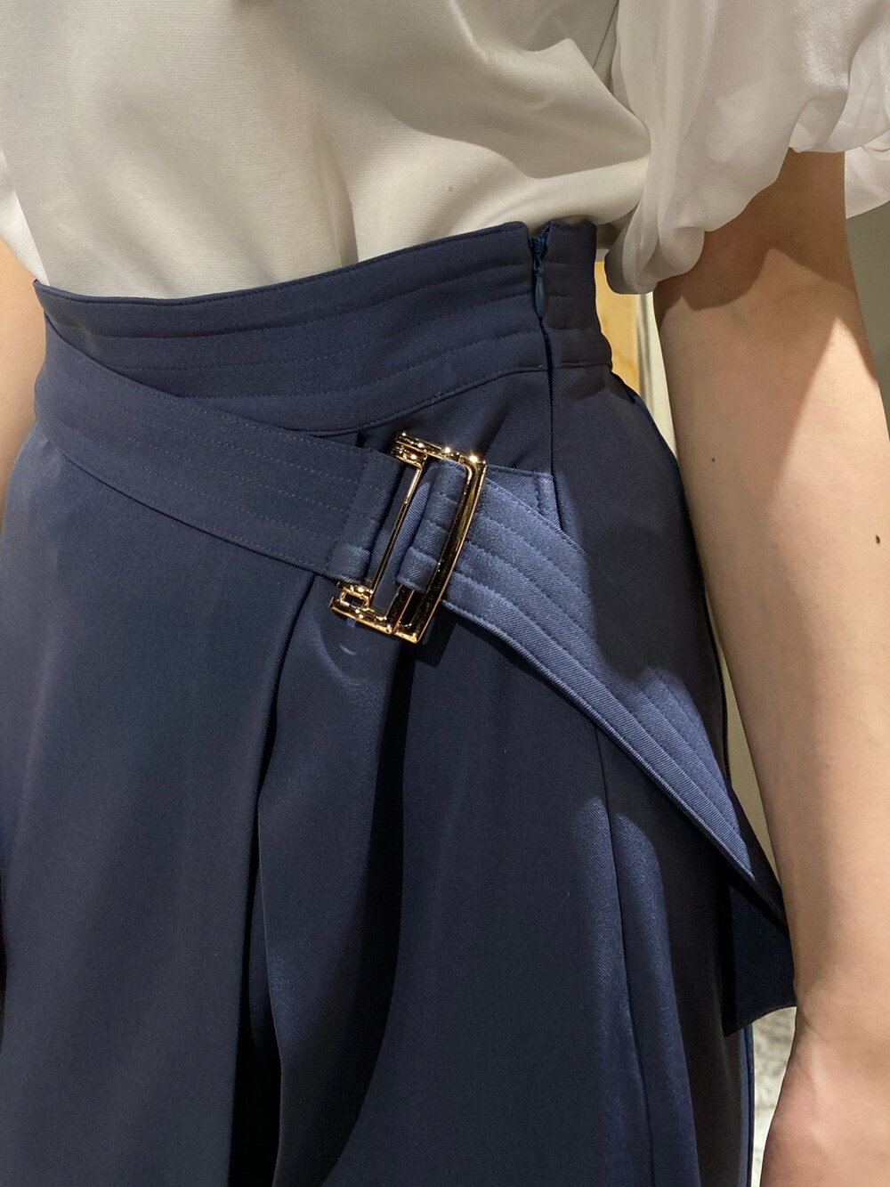 ホワイト系のハンドバッグ、ホワイト系のパンプス、ブルー系のスカートを着用したレディースの春コーディネートの6枚目の写真