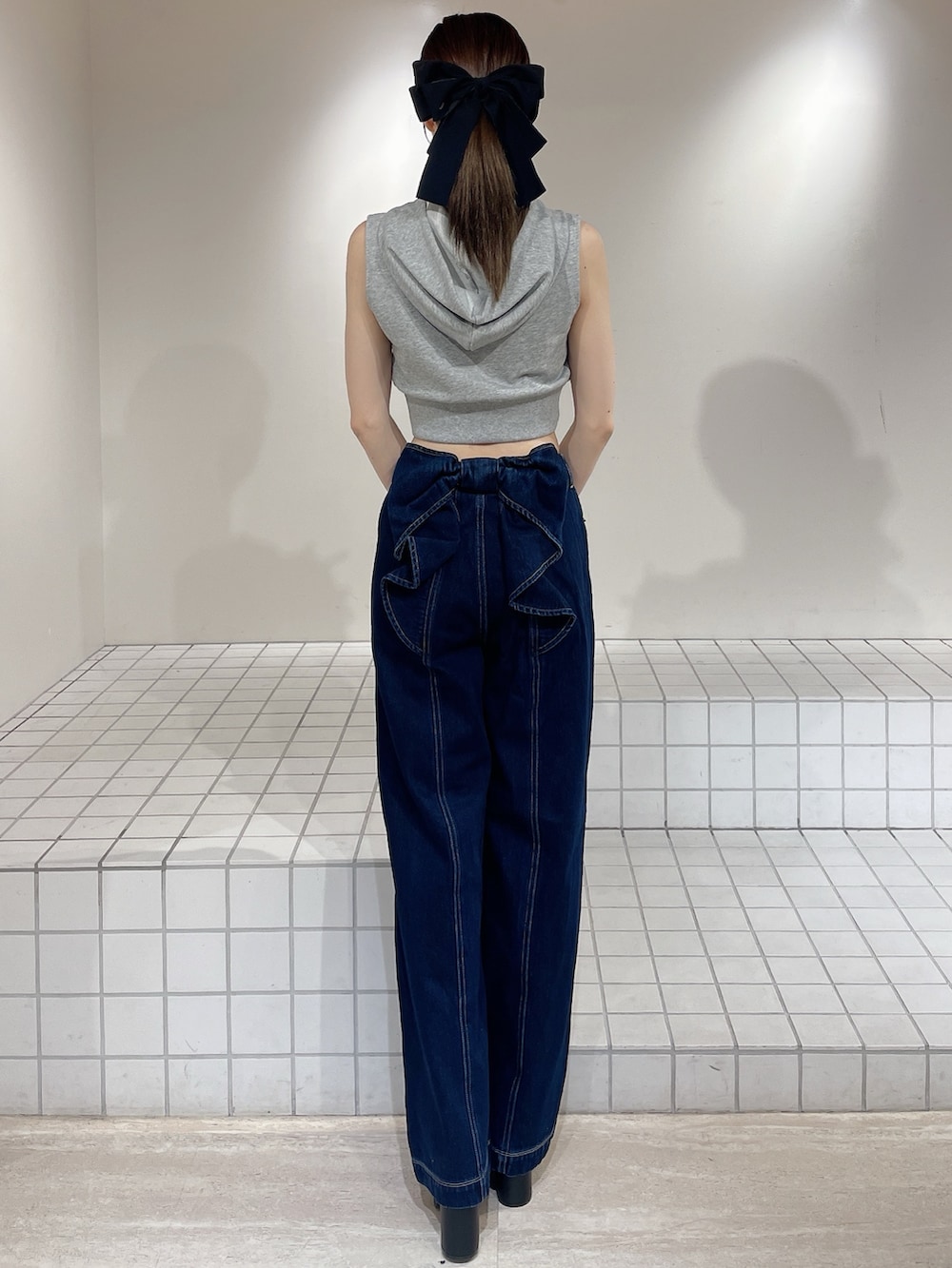 グレー系のパーカー、ブルー系のデニムパンツ、ブラック系のサンダルを着用したレディースの春コーディネートの3枚目の写真
