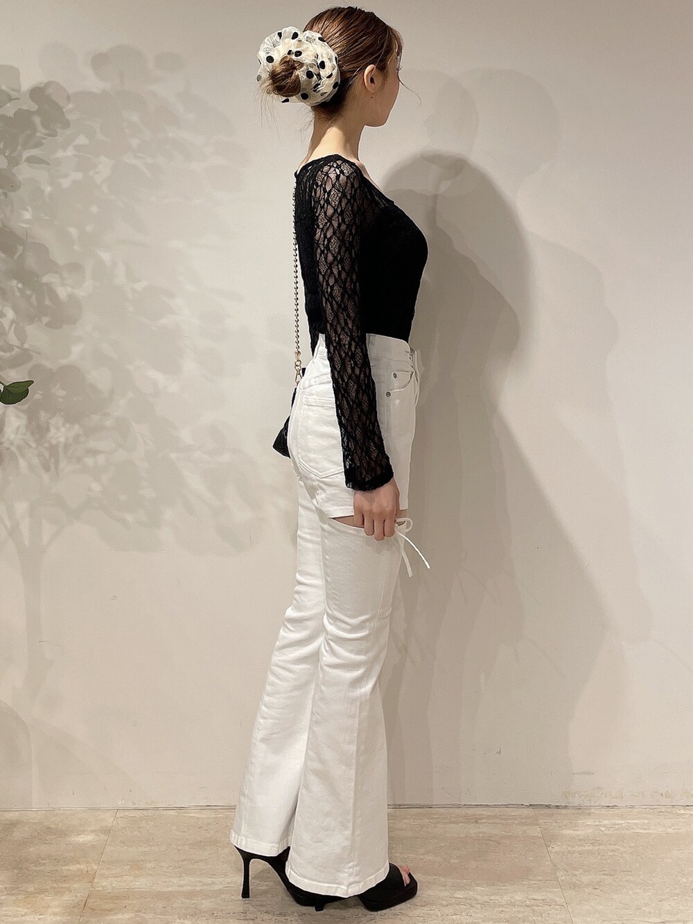 ブラック系のライダースジャケット、ホワイト系のデニムパンツ、ブラック系のブーツを着用したレディースの春コーディネートの6枚目の写真