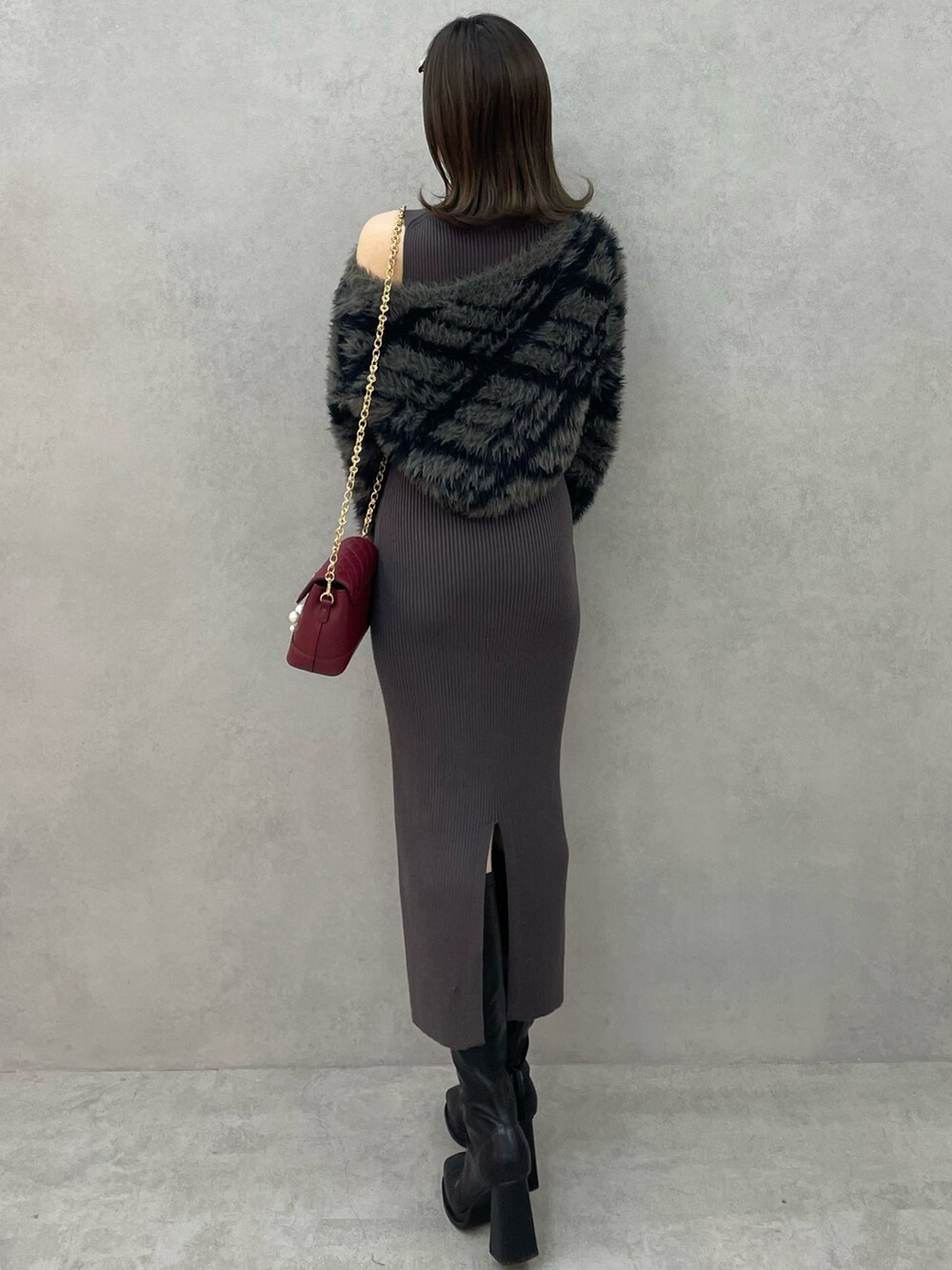 グレー系のワンピース、レッド系のショルダーバッグ、ブラック系のブーツを着用したレディースの秋コーディネートの4枚目の写真