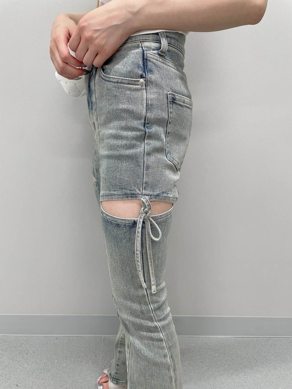 ピンク系のニット/セーター、ブルー系のデニムパンツ、ブラック系のサンダルを着用したレディースの春コーディネートの7枚目の写真