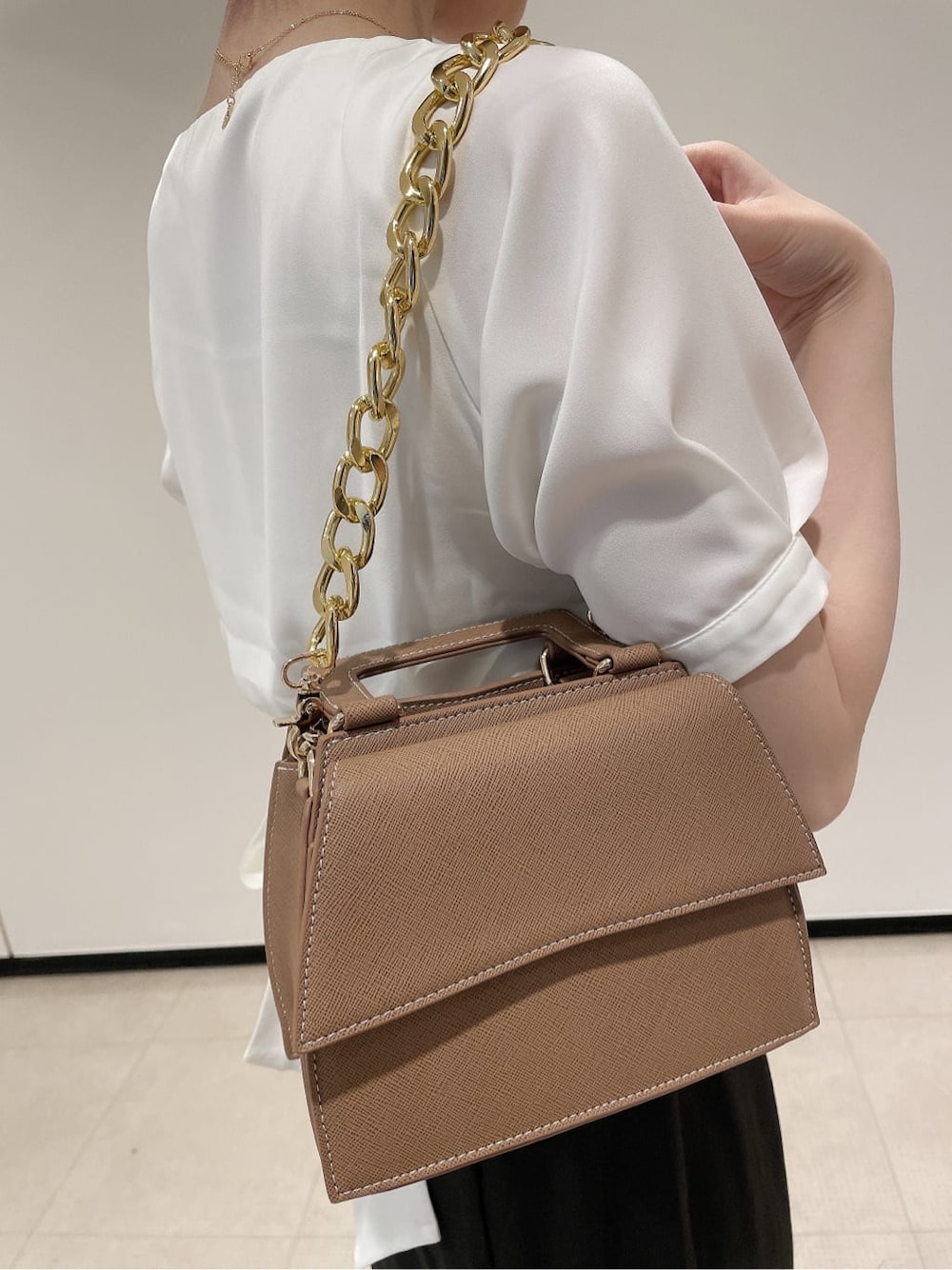ホワイト系のパンプス、ブラウン系のショルダーバッグ、ホワイト系のシャツ/ブラウスを着用したレディースの夏コーディネートの7枚目の写真
