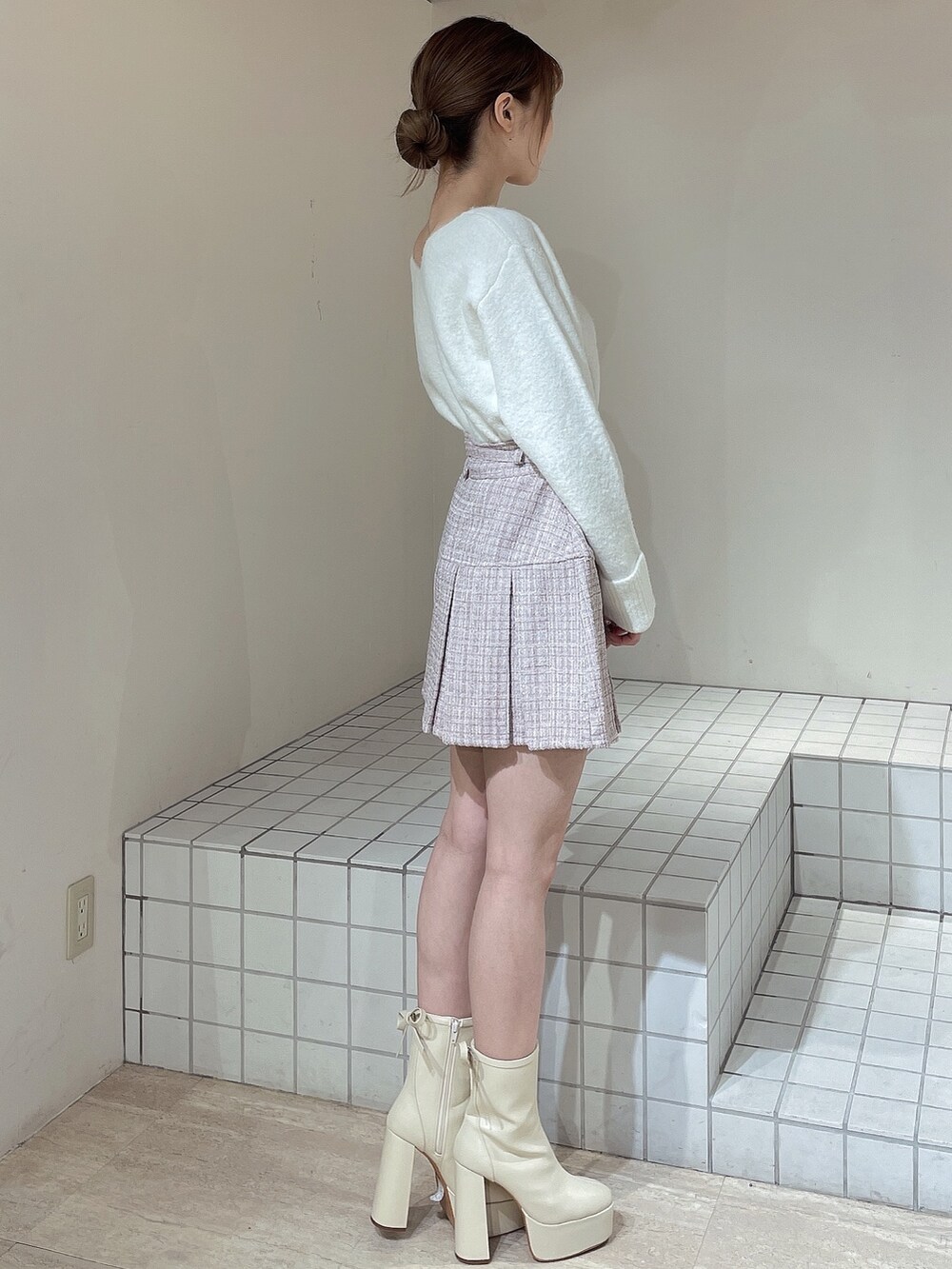 ピンク系のその他アウター、ピンク系のスカート、ホワイト系のニット/セーターを着用したレディースの冬コーディネートの6枚目の写真