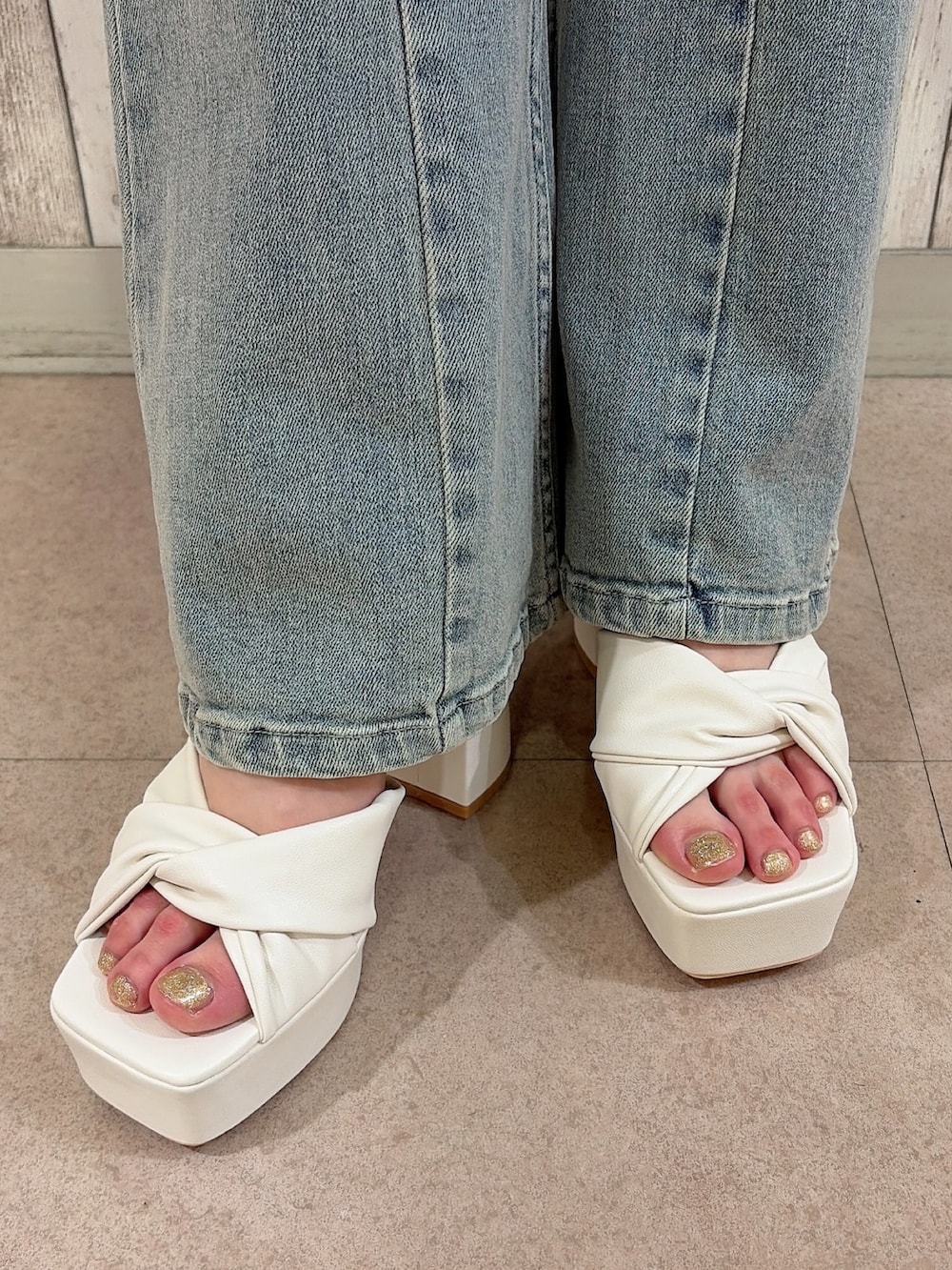 ホワイト系のニット/セーター、ブルー系のデニムパンツ、ホワイト系のハンドバッグを着用したレディースの夏コーディネートの8枚目の写真
