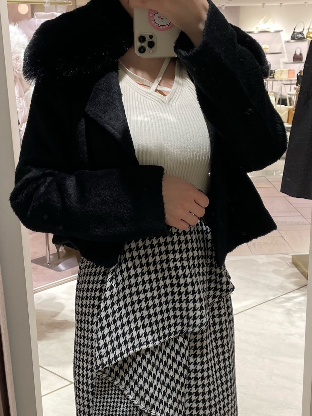 ブラック系のその他アウター、ホワイト系のニット/セーター、その他のスカートを着用したレディースの秋コーディネートの3枚目の写真