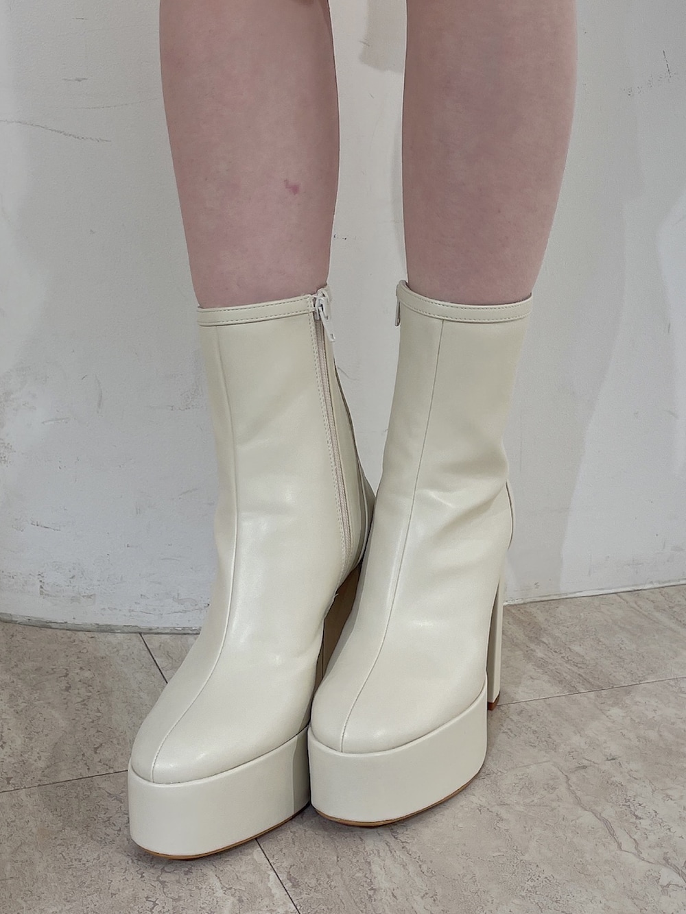 レッド系のニット/セーター、ブルー系のデニムパンツ、ホワイト系のブーツを着用したレディースの冬コーディネートの8枚目の写真