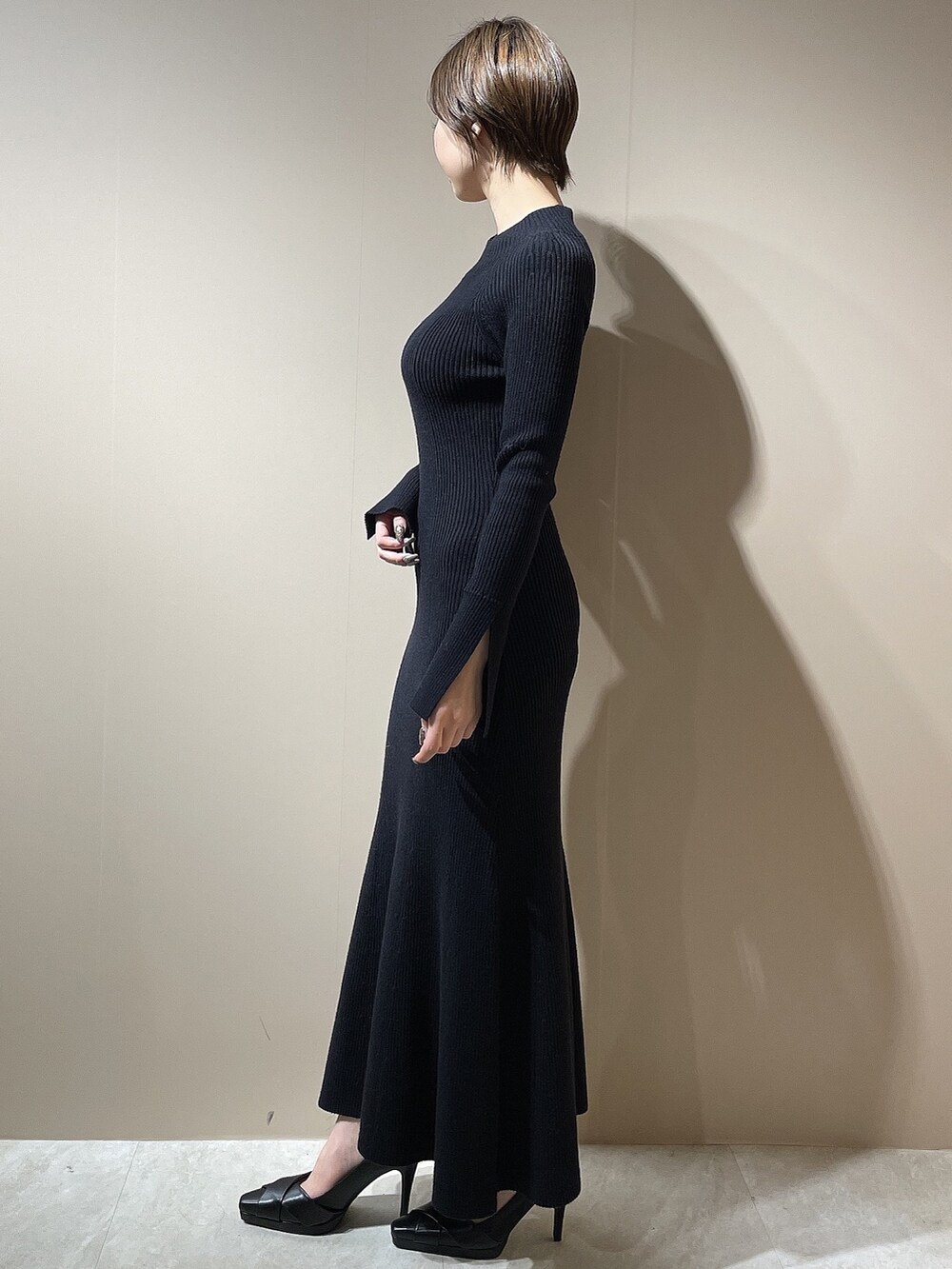 ブラック系のワンピース、ブラック系のパンプスを着用したレディースの秋コーディネートの4枚目の写真