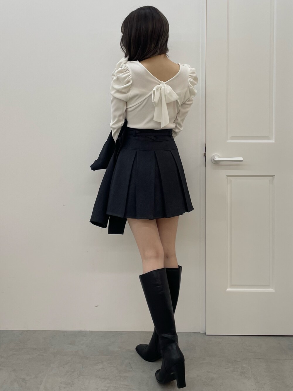 グレー系のテーラードジャケット、グレー系のスカート、ブラック系のブーツを着用したレディースの夏コーディネートの6枚目の写真