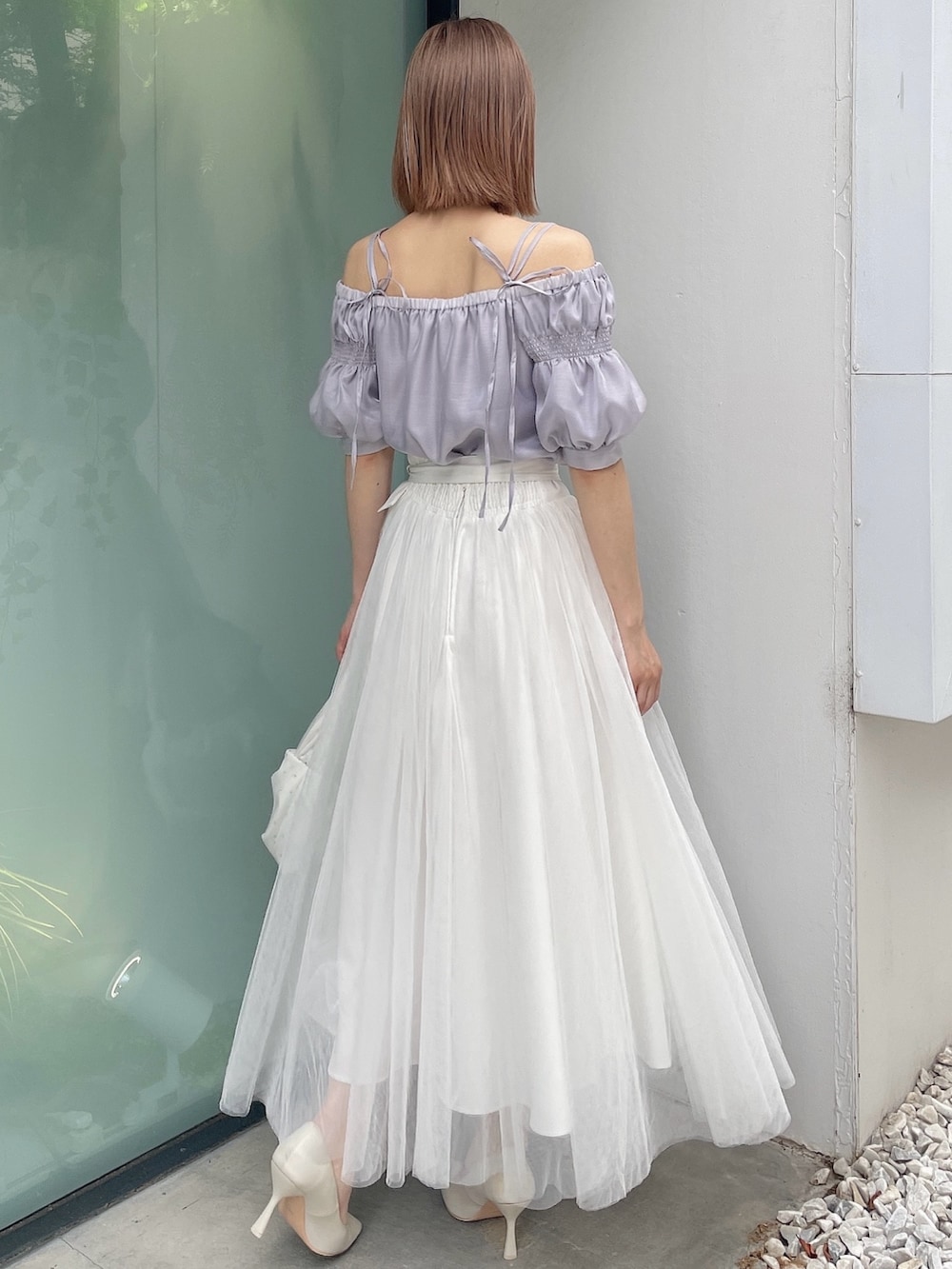 ホワイト系のスカート、ホワイト系のハンドバッグ、パープル系のシャツ/ブラウスを着用したレディースの夏コーディネートの4枚目の写真