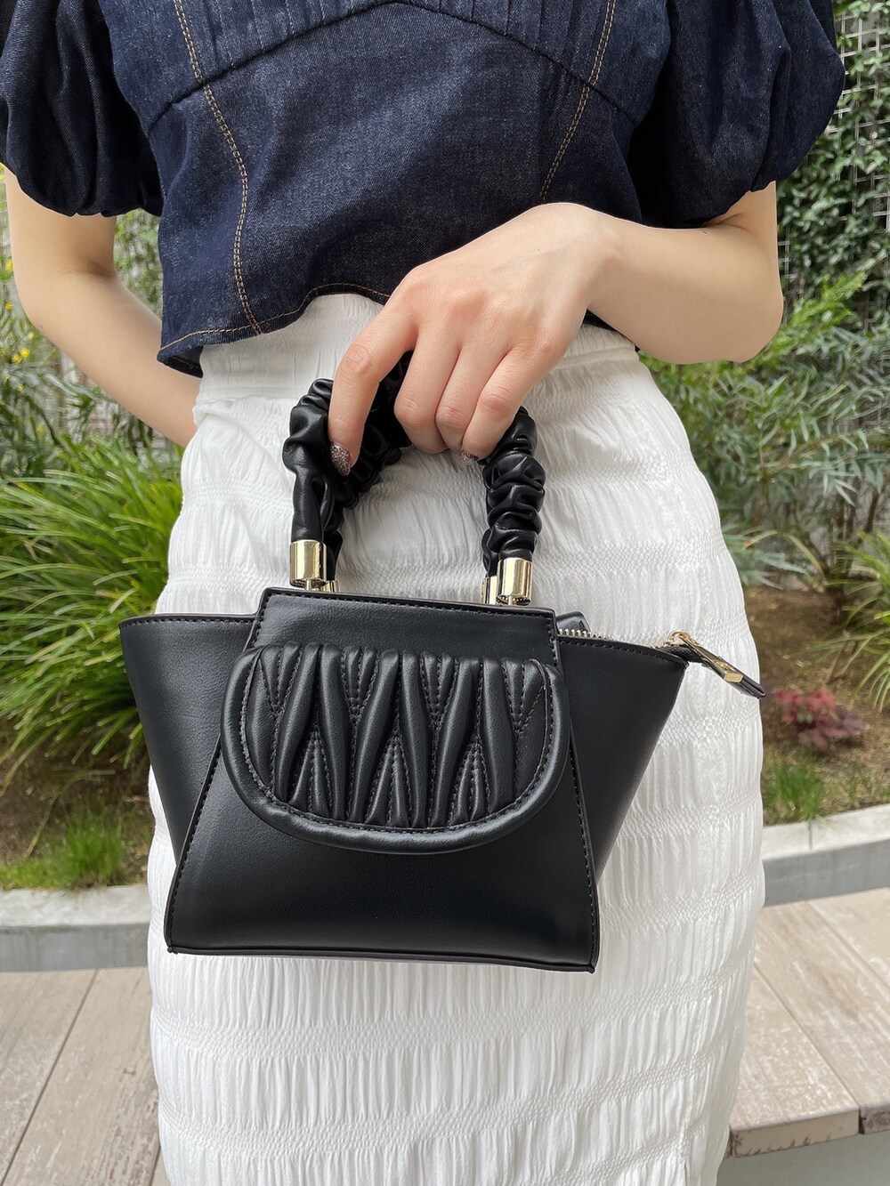 ブルー系のシャツ/ブラウス、ブラック系のハンドバッグ、ブラック系のサンダルを着用したレディースの春コーディネートの7枚目の写真