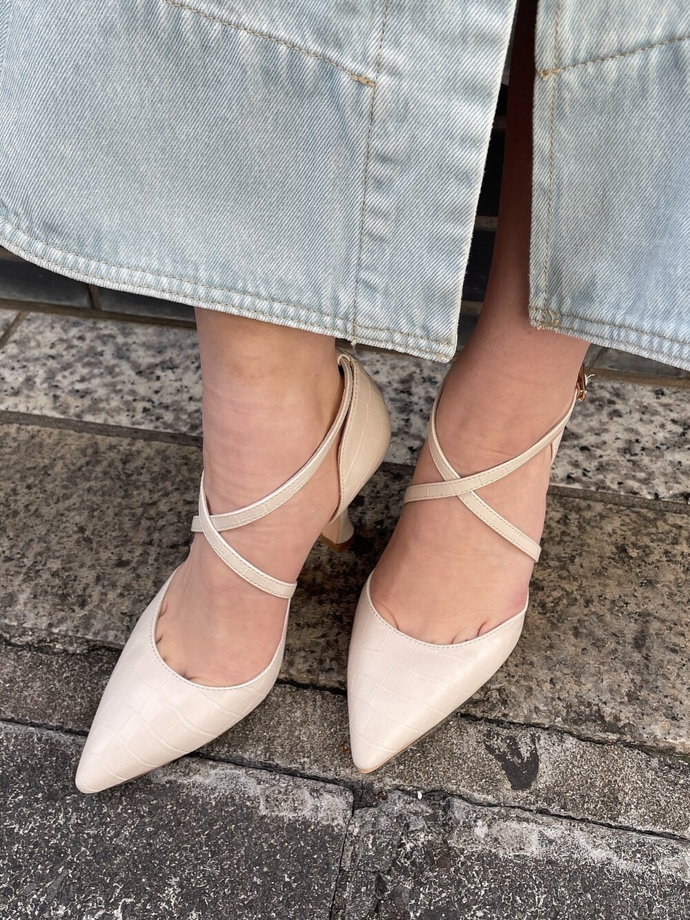 ブラック系のワンピース、ホワイト系のパンプスを着用したレディースの冬コーディネートの7枚目の写真