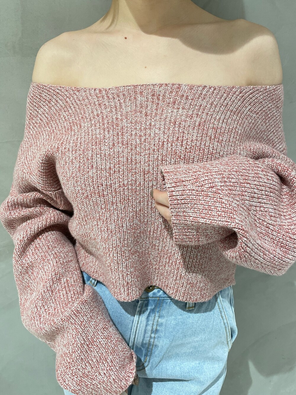 ピンク系のニット/セーター、ホワイト系のハンドバッグ、ブルー系のデニムパンツを着用したレディースの冬コーディネートの5枚目の写真