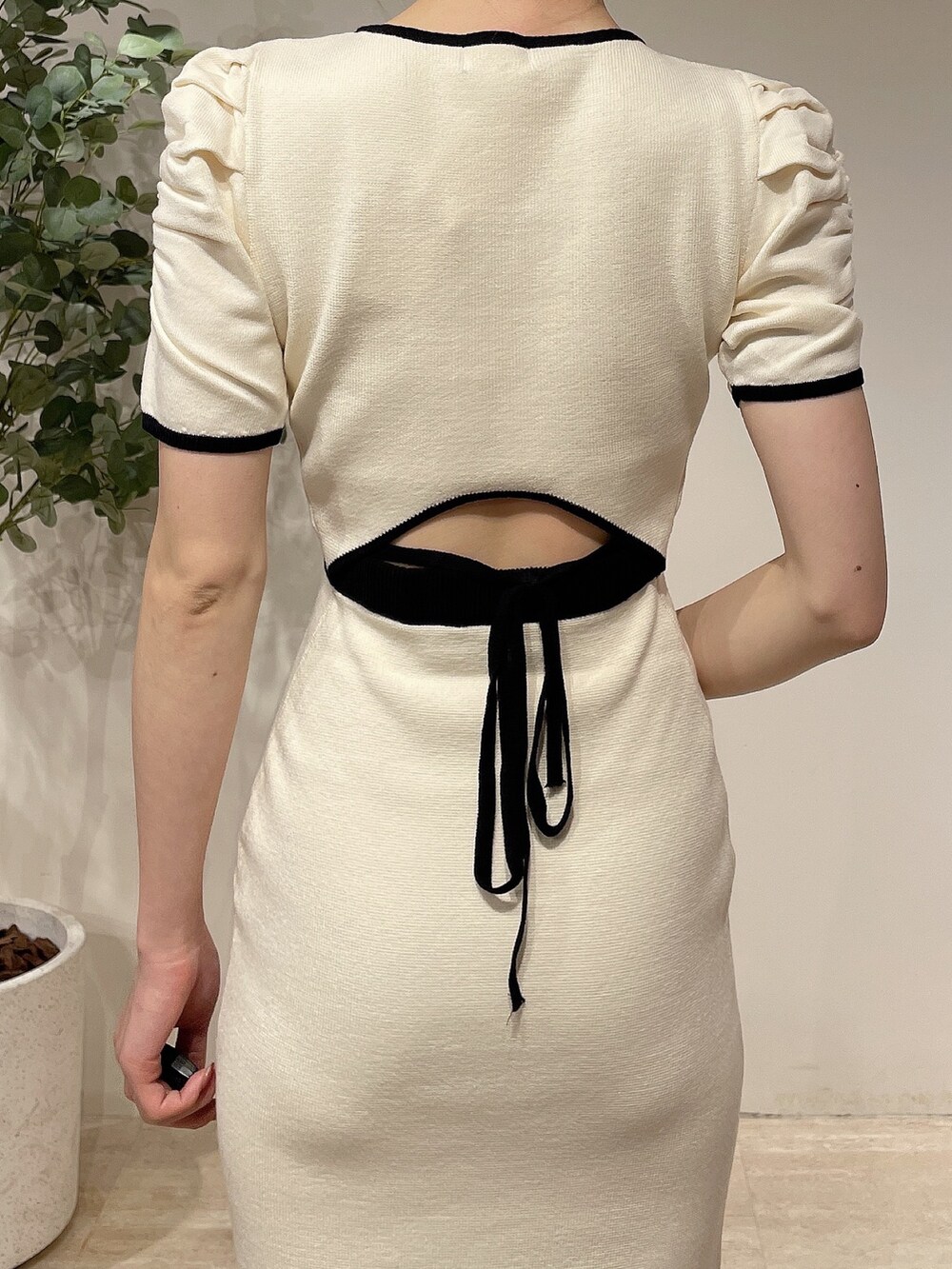 ホワイト系のライダースジャケット、ホワイト系のワンピース、ベージュ系のサンダルを着用したレディースの春コーディネートの8枚目の写真