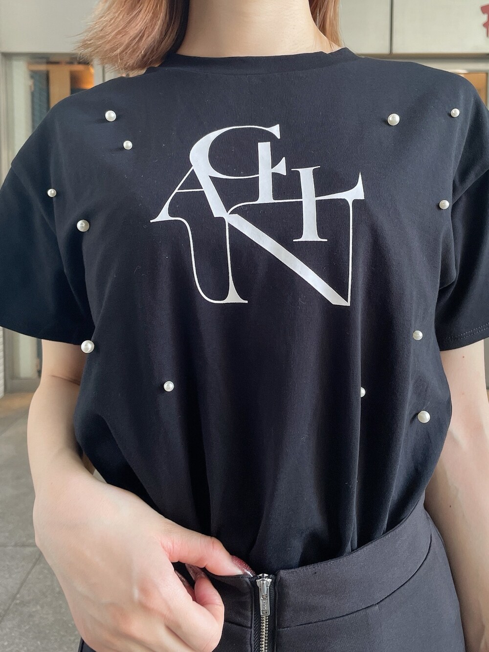 ブラック系のスリッポン、ブラック系のTシャツ/カットソー、ブラック系のスカートを着用したレディースの夏コーディネートの6枚目の写真