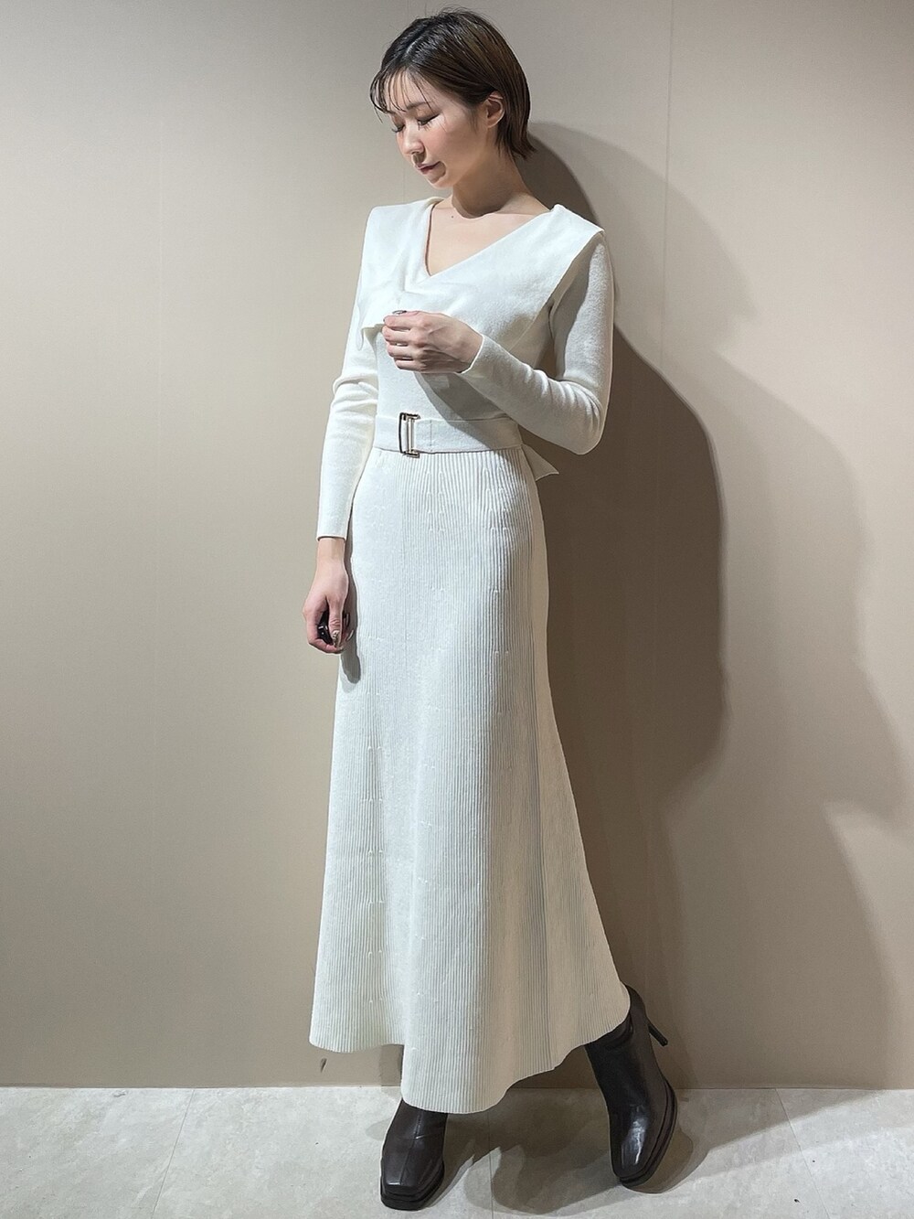 ホワイト系のダウンジャケット/コート、ホワイト系のワンピース、ブラウン系のブーツを着用したレディースの秋コーディネートの5枚目の写真