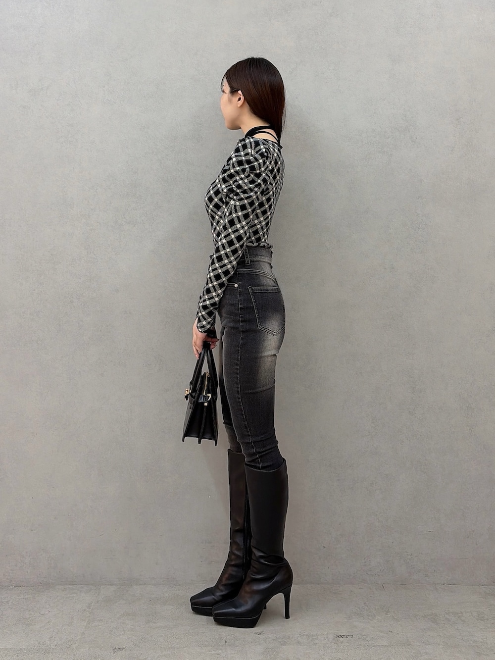 その他のニット/セーター、ブラック系のデニムパンツ、ブラック系のハンドバッグを着用したレディースの秋コーディネートの3枚目の写真