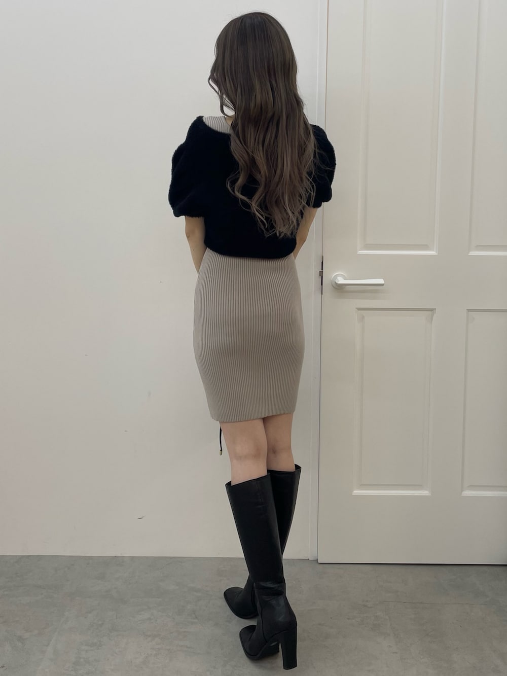 ブラック系のワンピース、ブラック系のハンドバッグ、ブラック系のブーツを着用したレディースの夏コーディネートの3枚目の写真