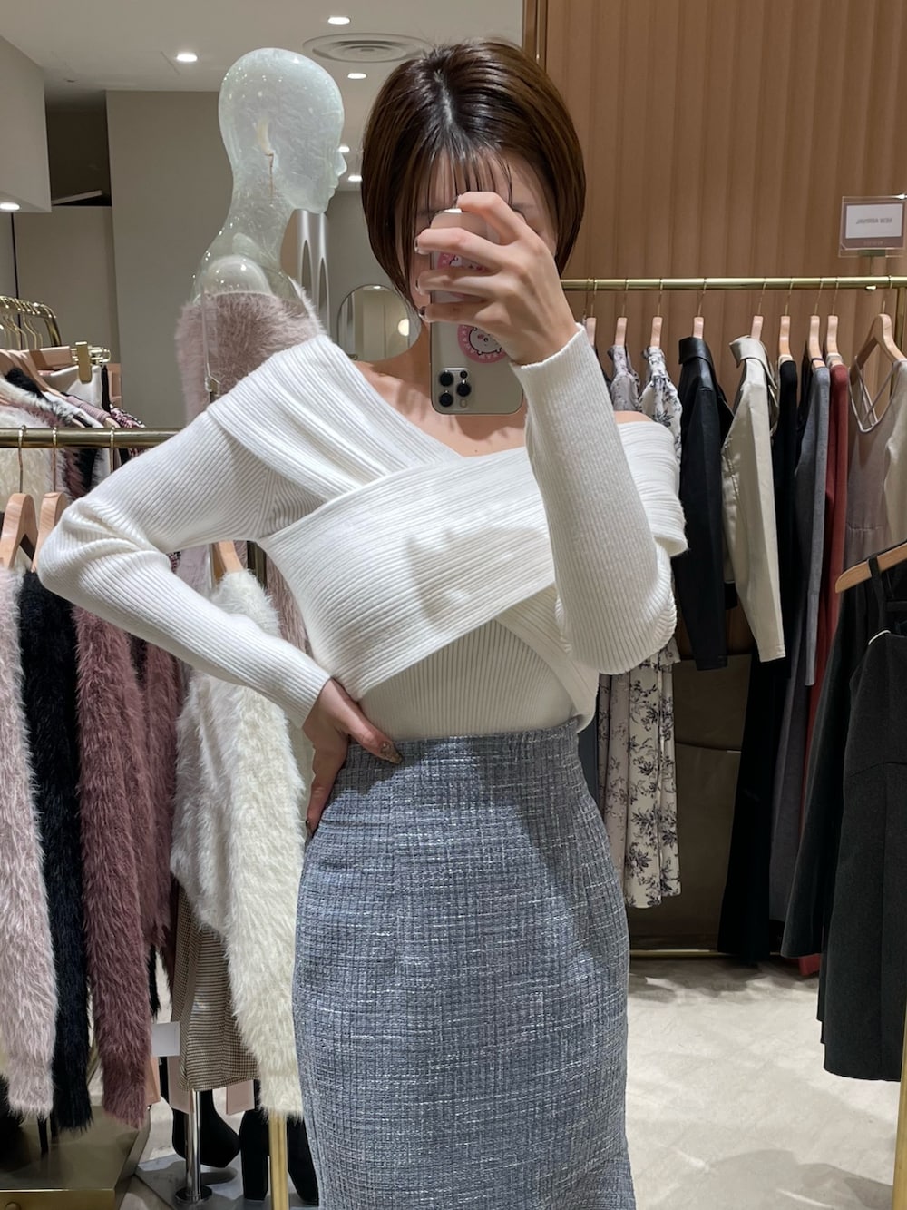 ホワイト系のニット/セーター、ブルー系のスカート、ベージュ系のサンダルを着用したレディースの秋コーディネートの3枚目の写真