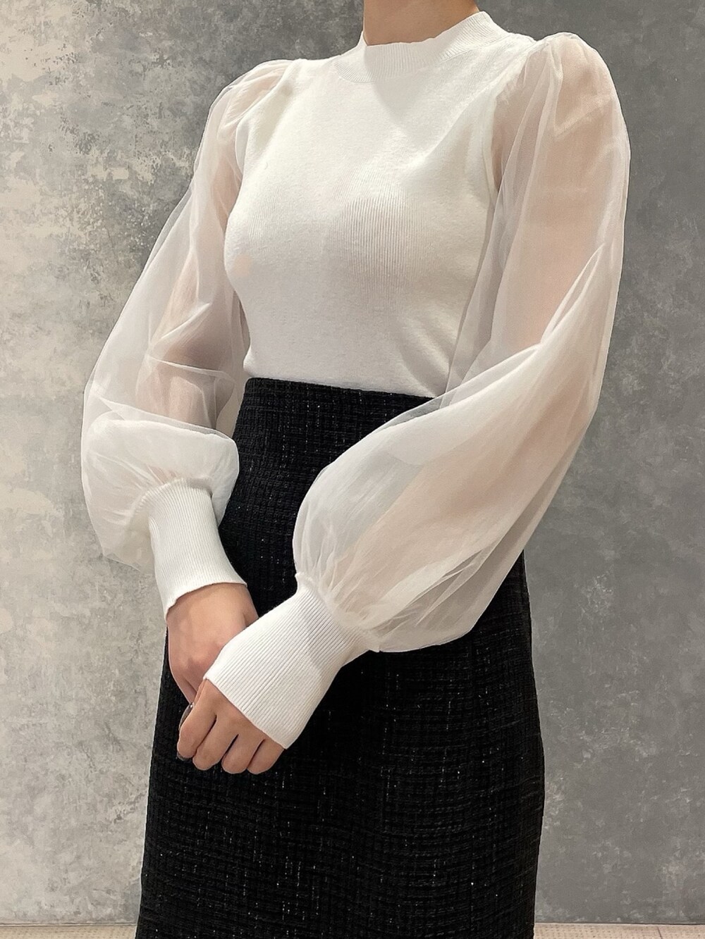 ホワイト系のダウンジャケット/コート、ブラック系のスカート、ブラック系のブーツを着用したレディースの秋コーディネートの9枚目の写真