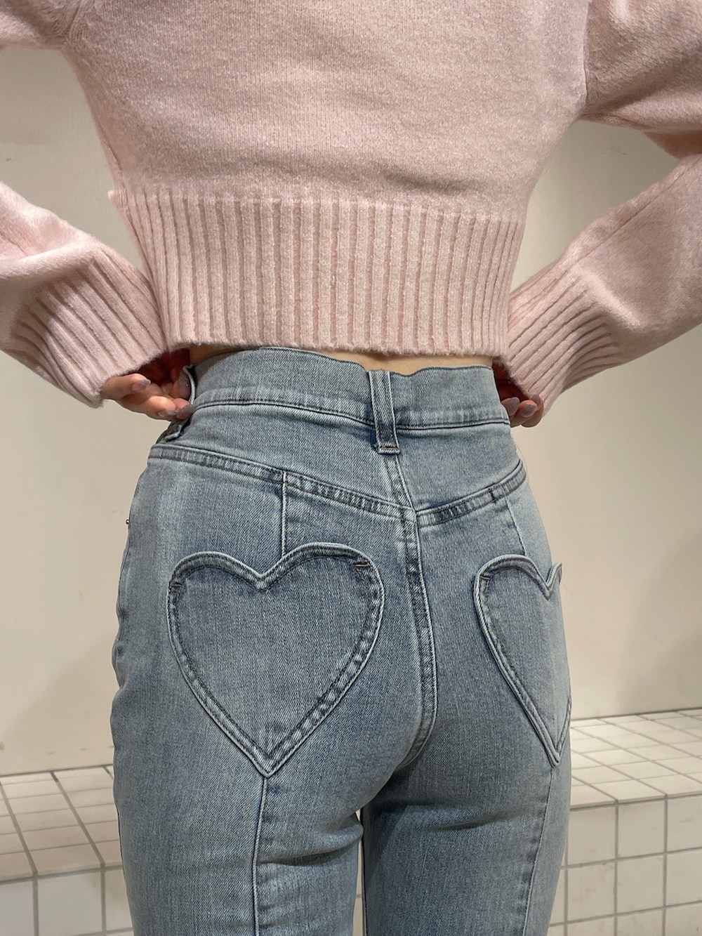 ピンク系のニット/セーター、ブルー系のデニムパンツ、ホワイト系のブーツを着用したレディースの冬コーディネートの7枚目の写真