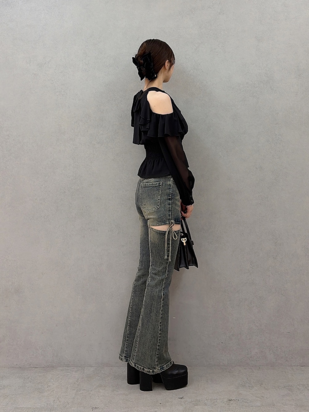 ブラック系のシャツ/ブラウス、ブルー系のデニムパンツ、ブラック系のハンドバッグを着用したレディースの秋コーディネートの2枚目の写真