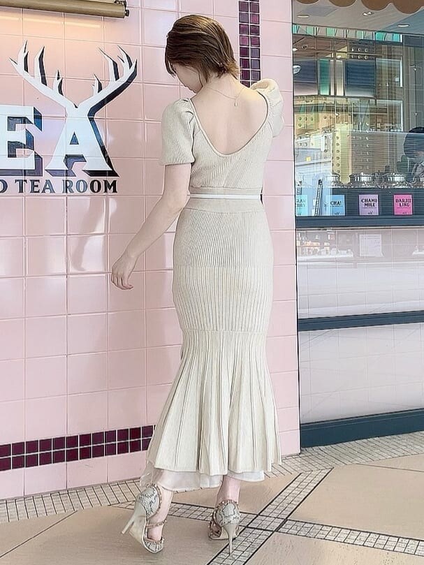 ベージュ系のワンピース、その他のパンプス、ゴールド系のネックレスを着用したレディースの春コーディネートの2枚目の写真