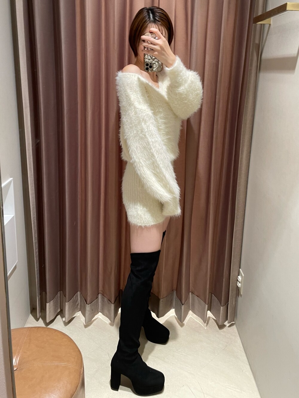 ホワイト系のワンピース、ブラック系のブーツを着用したレディースの秋コーディネートの3枚目の写真