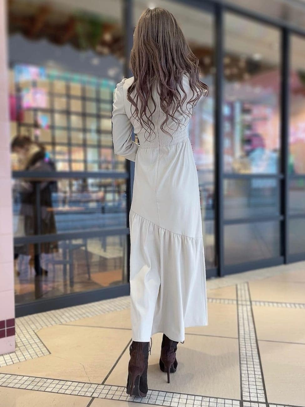 ベージュ系のワンピース、パープル系のトレンチコート、ブラウン系のブーツを着用したレディースの冬コーディネートの6枚目の写真