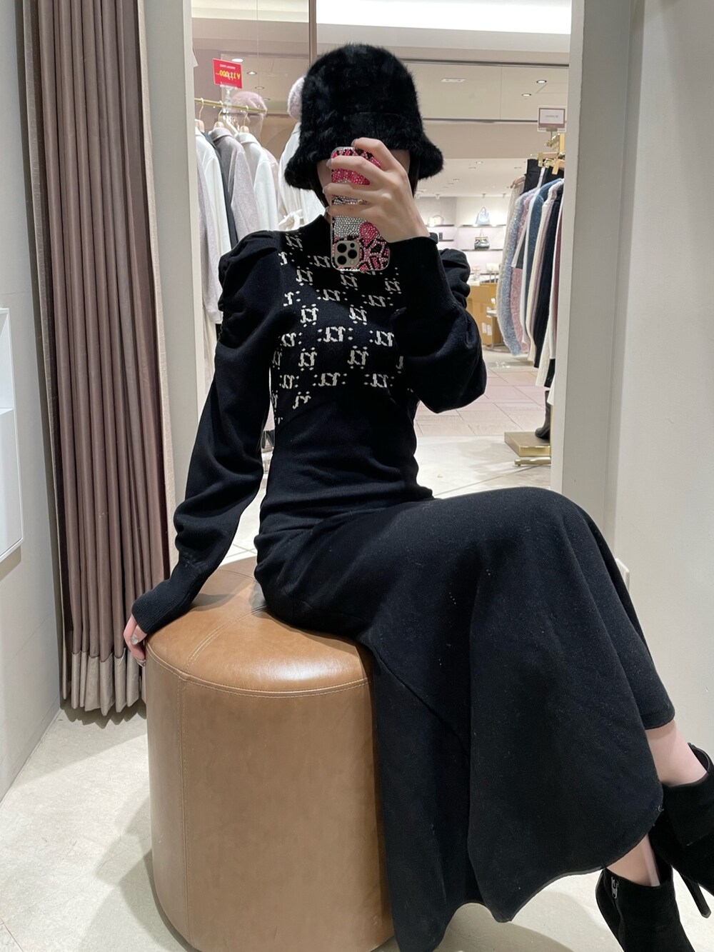 ブラック系のワンピース、ブラック系のブーツを着用したレディースの冬コーディネートの6枚目の写真