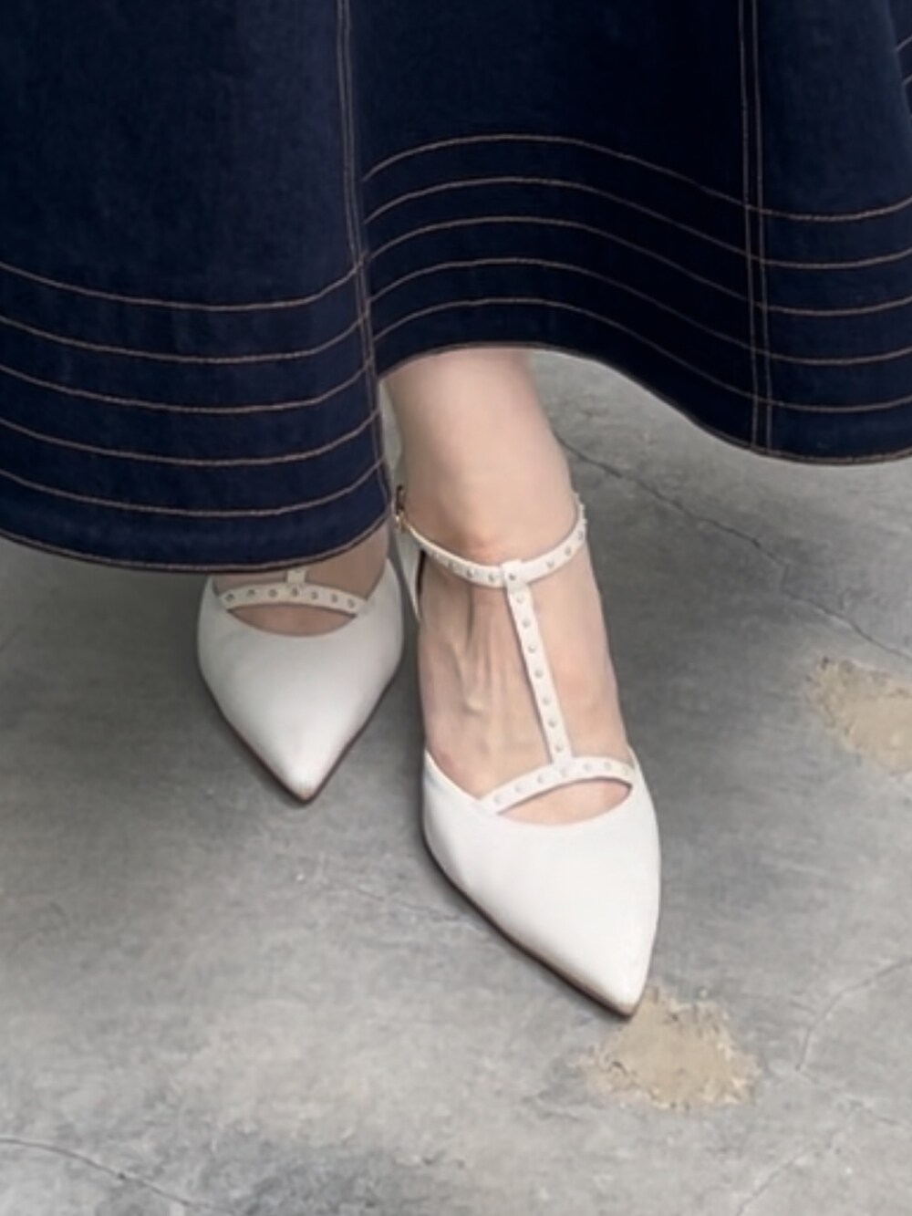 ブラック系のニット/セーター、ブラック系のスカート、ホワイト系のパンプスを着用したレディースの夏コーディネートの7枚目の写真