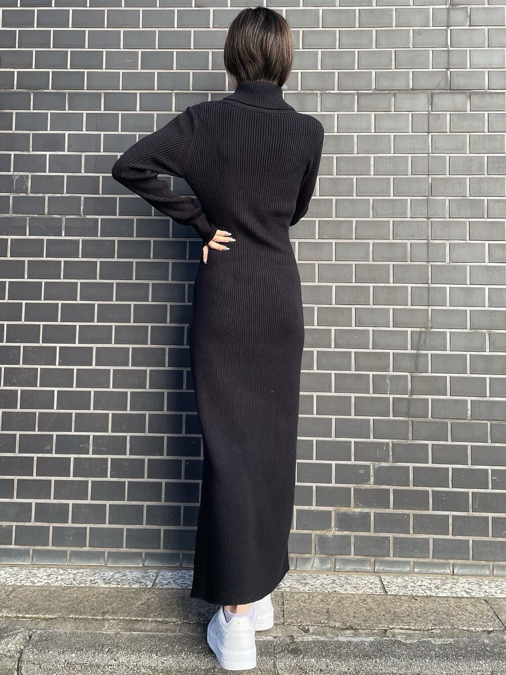 ブラック系のワンピース、ホワイト系のブルゾン、ホワイト系のスニーカーを着用したレディースの冬コーディネートの7枚目の写真