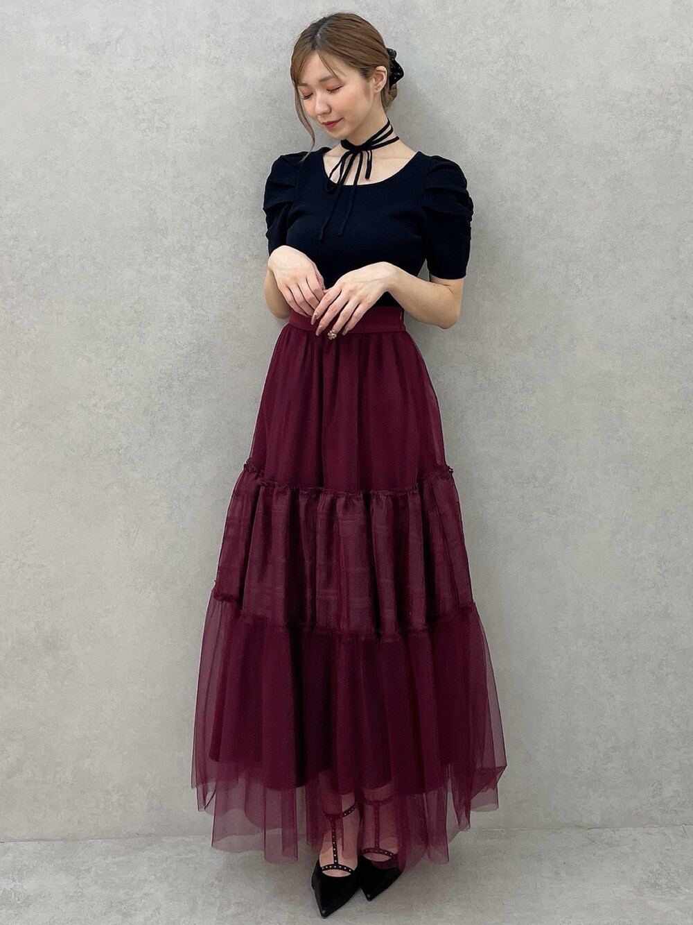 ブラック系のニット/セーター、レッド系のスカート、ブラック系のパンプスを着用したレディースの夏コーディネートの2枚目の写真