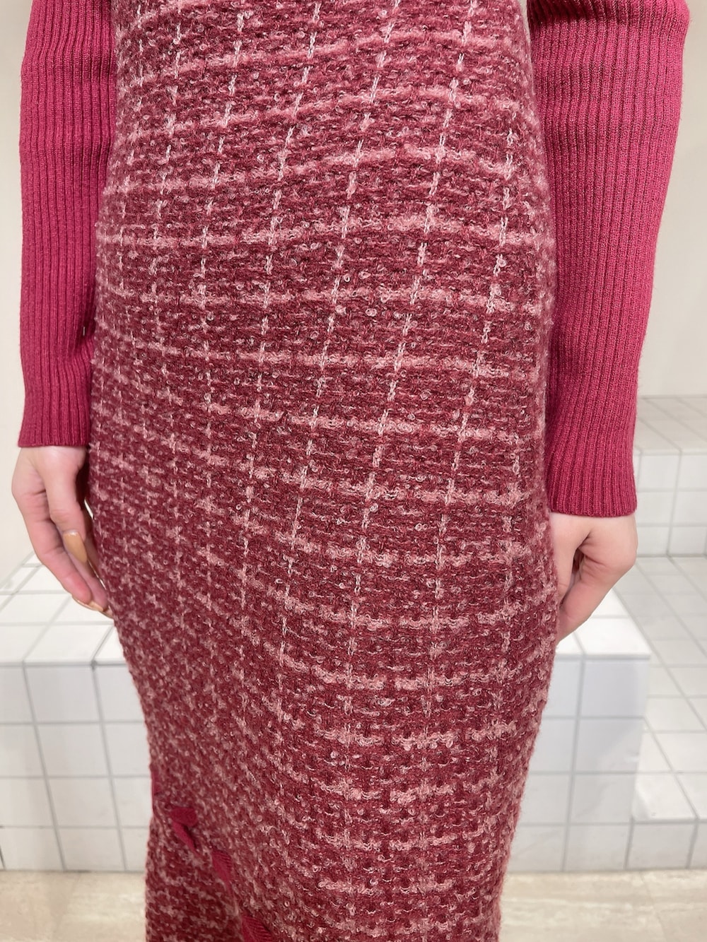 レッド系のワンピース、ブラック系のブーツ、ブラック系のバレッタ/ヘアクリップを着用したレディースの冬コーディネートの6枚目の写真