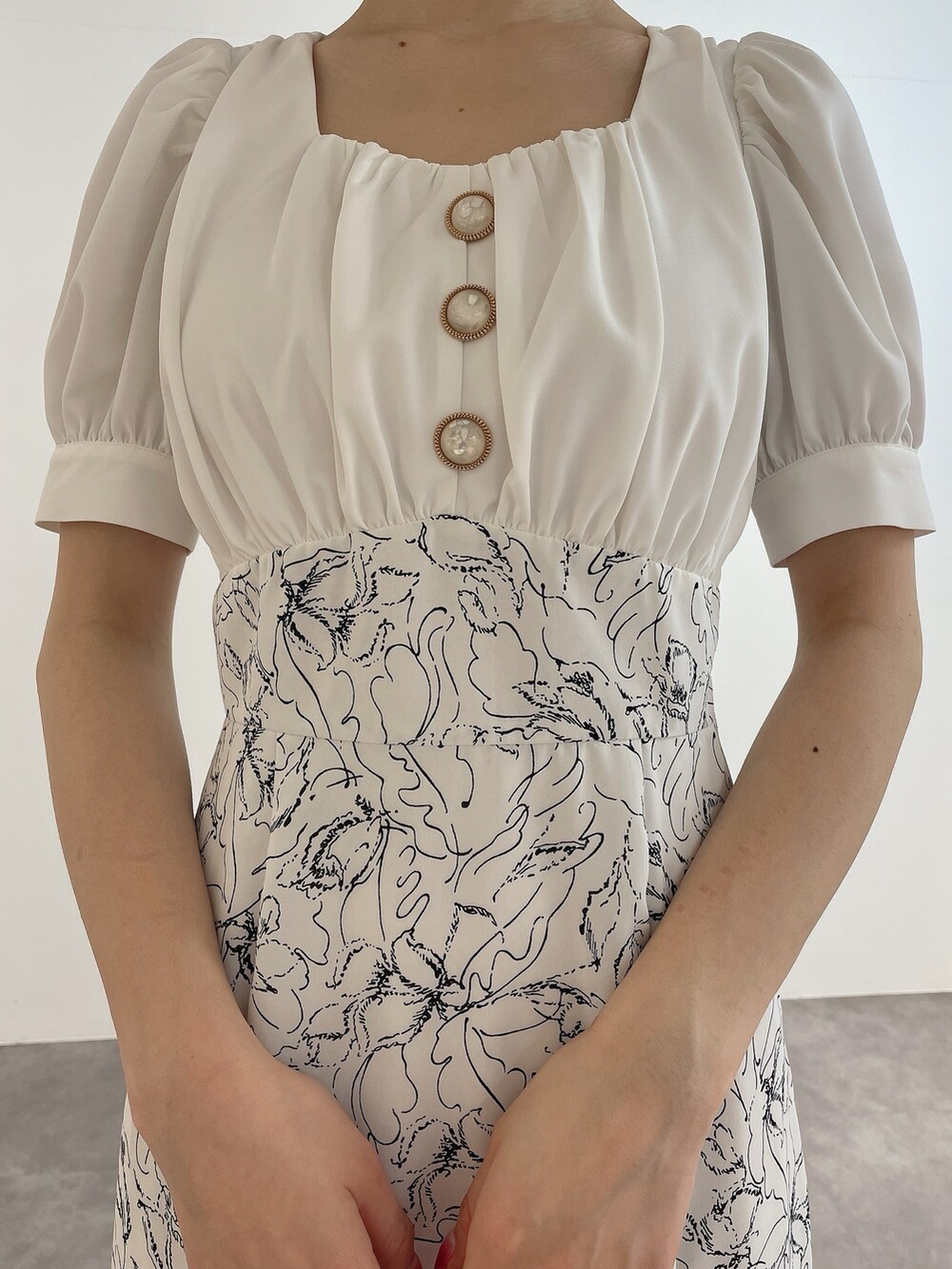 ホワイト系のワンピース、ホワイト系のハンドバッグ、ホワイト系のパンプスを着用したレディースの春コーディネートの6枚目の写真