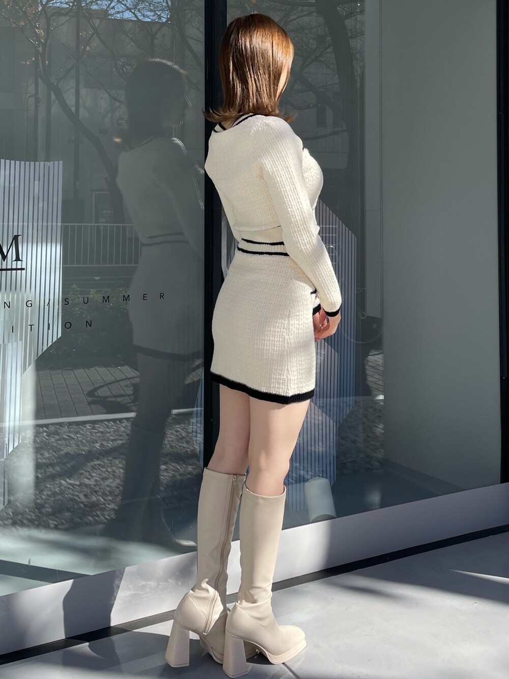 ホワイト系のダウンジャケット/コート、ホワイト系のニット/セーター、ホワイト系のスカートを着用したレディースの冬コーディネートの6枚目の写真